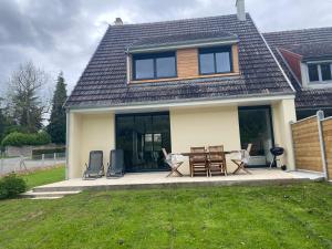 ein Haus mit einer Terrasse mit Stühlen und einem Tisch in der Unterkunft La chapelle in Fervaches