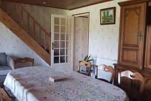 a room with a table and chairs and a staircase at Le Mimosa, maison de vacances in Trans-la-Forêt