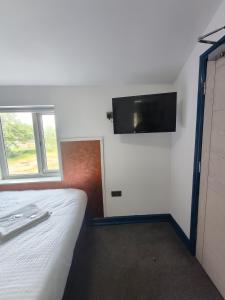 a bedroom with a bed and a tv on the wall at Park City Rooms in Manchester +21 photos
