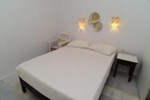 a white bed in a room with a table and a mirror at Paradise Pirgaki Naxos in Agiassos +57 photos