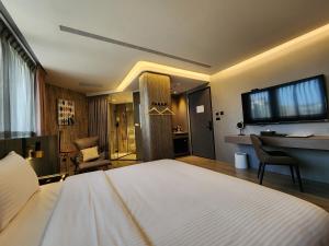 a bedroom with a large bed and a desk in it at 花蓮品悅文旅Hualien Pink Corner Hotel in Hualien City