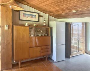 eine Küche mit einem Holzschrank und einem Kühlschrank in der Unterkunft Maison de 3 chambres avec jardin clos et wifi a Vendays Montalivet a 7 km de la plage in Vendays-Montalivet