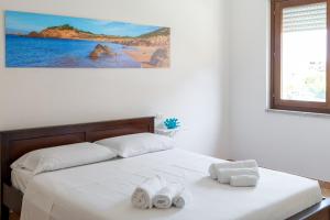 a bedroom with a bed with two towels on it at Appartamenti Le Vele in La Maddalena