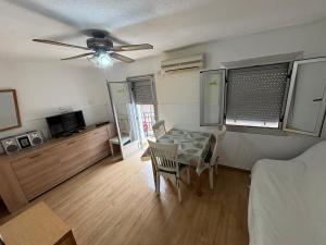 a living room with a table and a ceiling fan at Casita-apartamento individual Calle Los Dolores , 3 habitaciones in Benicàssim