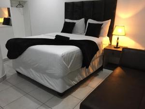 a bedroom with a large bed with a black headboard at De Bliss Lodge in Johannesburg