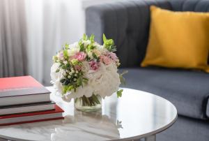 a vase of flowers on a table next to books at Mandarin Oriental, Geneva in Geneva