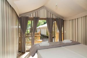 因普鲁内塔hu Firenze Certosa camping in town的一间带床和大窗户的卧室