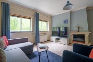 a living room with a couch and a tv at Apartamento T3 em Pombal in Pombal