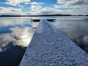 a dock in the middle of a lake with snow at Domki nad jeziorem Kolonia Rybacka in Kolonia Rybacka