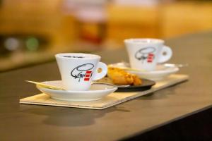 dos tazas de café en una mesa con platos de comida en Ristorante Groven en Lostallo