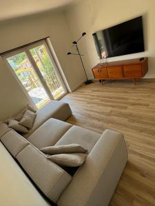 a living room with a couch and a flat screen tv at Villa Mave - Cascais in Estoril