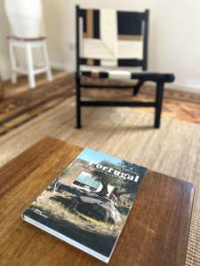 a magazine sitting on a table next to a chair at Quinta Felicidade - Sea&Surf in Óbidos