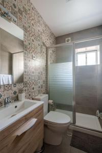 a bathroom with a toilet and a sink and a shower at Apartamento T3 em Pombal in Pombal