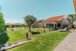 a house with a yard with a grassy field at Páteo Sagaipo in Lourinhã