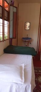 1 dormitorio con cama blanca y lavamanos en Himalayan Homestay Huddu Valley, en Chopta