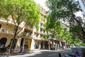 uma rua com árvores e edifícios numa cidade em Fira Suites em Barcelona