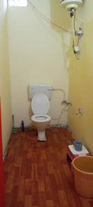 baño con aseo y suelo de madera en Himalayan Homestay Huddu Valley, en Chopta