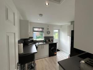 una cucina con lavandino e piano cottura di sark house Apartment Chorlton manchester a Manchester