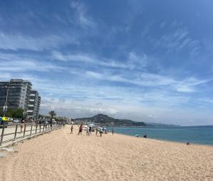 a group of people walking on a beach at APCOSTAS Villa de Madrid in Blanes