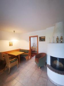 a living room with a fireplace and a table and chairs at Gästehaus Thaler in Mittelberg