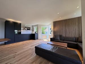 sala de estar con sofá negro y cocina en Am Bodensee-Radweg, en Überlingen