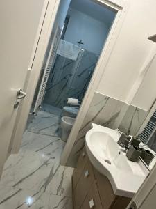 La salle de bains est pourvue d'un lavabo, de toilettes et d'un miroir. dans l'établissement casa vacanze sweethome, à La Spezia