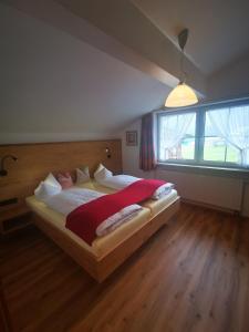 a bedroom with a large bed with a large window at Gästehaus Thaler in Mittelberg