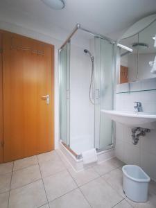 a bathroom with a shower and a toilet and a sink at Gästehaus Thaler in Mittelberg
