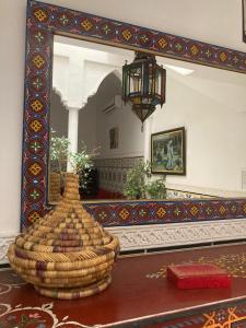 - un miroir dans une chambre avec un panier sur une table dans l'établissement RIAD Lalla Aicha-Qariya Siyahia Marrakech, à Marrakech