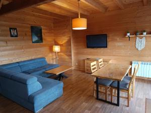 a living room with a blue couch and a table at Katilux willa in Nowy Targ