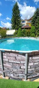 a large swimming pool in a stone wall at Katilux willa in Nowy Targ