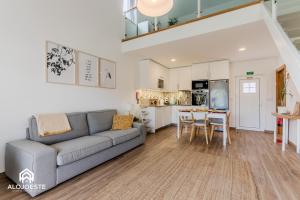 a living room with a couch and a kitchen at Páteo Sagaipo in Lourinhã