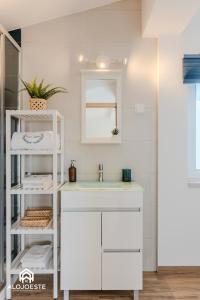 a white bathroom with a sink and a mirror at Páteo Sagaipo in Lourinhã