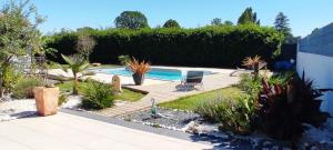 a garden with a swimming pool and a chair at MAISON de VACANCES in Seyresse