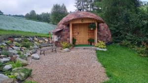 a small wooden building with a bench in a garden at Katilux willa in Nowy Targ