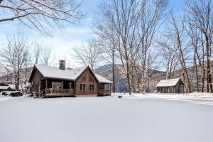 una baita di tronchi con neve a terra di Cozy Log Cabin on the River with Fireplace and Loft a Townshend