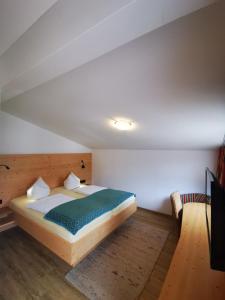 een slaapkamer met een bed en een bank in een kamer bij Gästehaus Thaler in Mittelberg