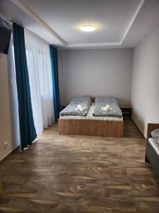 Schlafzimmer mit einem Bett und Holzboden in der Unterkunft Restauracja Biały Kruk in Górno