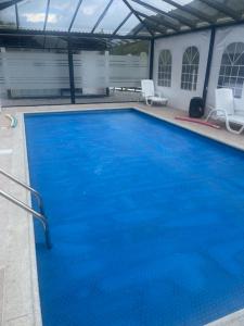 une grande piscine bleue dans un immeuble dans l'établissement Dogsland Pululahua - Bienvenidos - Ferienwohnungen, à Quito
