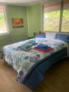 une chambre avec un lit avec une couette bleue et blanche dans l'établissement Dogsland Pululahua - Bienvenidos - Ferienwohnungen, à Quito