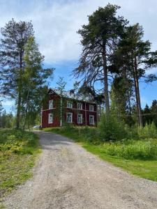 ein rotes Haus am Rande eines Feldwegs in der Unterkunft Wästinn in Vöyri