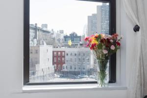 wazon kwiatów siedzący na parapecie w obiekcie Sunny Stylish West Village Condo w Nowym Jorku