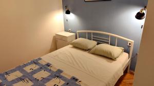 a bedroom with a bed with a blue and white blanket at Apartment Seventh Continent in Šibenik