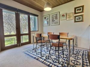 a room with a table and chairs on a rug at Snow Gums apartment 3 alpine -Getaways in Dinner Plain