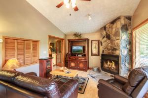 a living room with leather furniture and a fireplace at Cozy Bear Hideaway By Stony Brook Cabins in Cosby