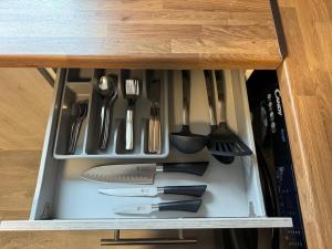 a drawer filled with utensils in a cabinet at Luxury Apartment in Ramsbottom