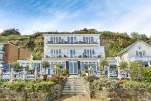 un gran edificio blanco con sillas delante en Gurnard At The Aqua, en Shanklin