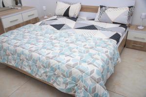 a bedroom with a bed with a blue and white comforter at RESIDENCE TERANGA immo luxe in Dakar