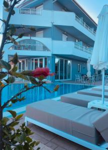 una donna sdraiata su un letto accanto alla piscina di Zante Pantheon Hotel a Tsilivi