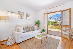 un soggiorno con un divano bianco e un tavolo di Villa Ido a Cala'n Bosch